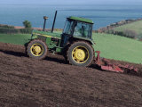 John Deere Tractor with a Rotivator on a Sloping Field in Spring  at Holcombe  Devon  England  UK