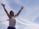 Male Runner Victorious at the Finish Line in a Track Race