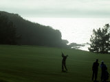Golfer in Action with Water View Beyond