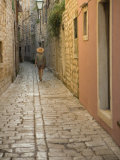 Woman walking in narrow cobblestone alley  Stari Grad Town  Hvar Island  Dalmatia  Croatia