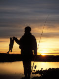 Silhouette of a Woman Holding Up Catch  The Brooks Range  Alaska  USA