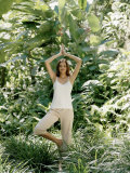 Young Pan-Asian Woman Standing in a Yoga Stance in a Jungle in Bali