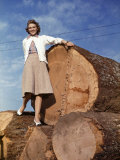 Woman Stands on a Pile of Gigantic Douglas Fir Logs