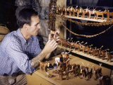 Wood Carver Poses with His Mule Figurines