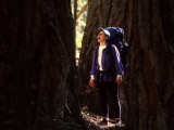 Woman Backpacking Through a Forest Stops to Howl