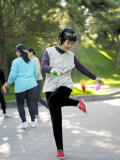 Elderly Woman Doing Her Daily Exercise by Kicking a Shuttercock