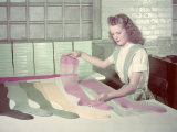 Woman Hunts for Flaws in Hosiery Laid on a White Inspection Table