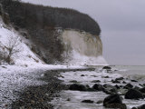 Snow-Dusted Rocky Beach at the Base of a Cliff