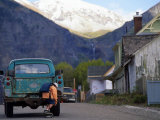 Boy on His Skateboard Catches a Ride from a Passing Truck