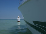 Man Tows a Boat from the Shore on a Hot Summer Day