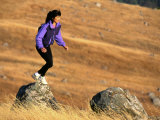 Woman Hoppin Boulders in a Field at Sunset