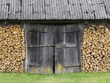 Barn Door Surrounded by Firewood Stacks
