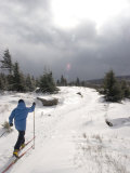 Woman Cross Country Skiing Along a Ridge Trail