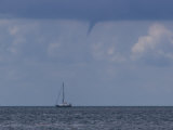 Developing Waterspout Passing over a Sailboat on Calm Seas