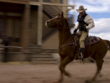 Cowboy Actor Riding a Horse on an Old Western Movie Set