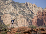 Man on a Unicycle Rides Along a Rocky Ridge in the Arizona Desert