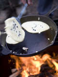 Man Cooks Pancakes with Freshly Picked Blueberries over a Campfire