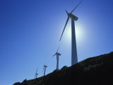 Wind Turbines Along a Ridge with Blue Sky and Sunlight