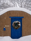 Snow Covered Christmas Wreath Adorns a Blue Door in Santa Fe