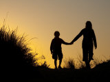 Seven Year Old Boy and His Mom Walk Hand in Hand Through Sand Dunes