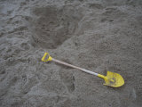Child's Shovel and Hole in the Sandy Beach