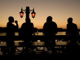 Visitors to Zambia Enjoy a Drink at Sunset Beside the Zambezi River