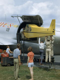 Men Load a Piper Cub into the Hold of a C-46