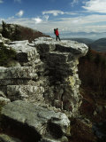 Hiker Standing at the Edge of a Rock Outcrop on a Cliff