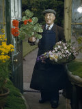 Gardener Wearing Suit and Apron Holds Containers of Flowers