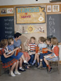 Teacher and Fellow Students Listen as a Boy Raises His Hand to Speak