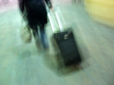 Unrecognizable Person Dragging Luggage Through San Francisco Airport