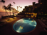 Couple Swimming at Sunset in a Hotel Pool Near the Beach