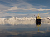 Work Boat in Still Water Near Snowy Mountains