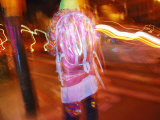 Young Person in Colorful Garb Walking a San Francisco Street at Night