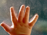 Close View of a Small Child's Hand on Dirty Glass