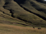 Three People on Horseback in a Landscape of Folding Hills