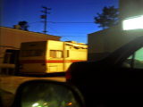 Trailer and Cars Parked Behind a Gas Station at Twilight
