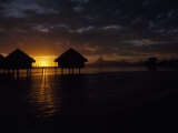 Bungalows over the Water at Sunset at an Exclusive Hotel on Tahiti