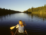 Woman Paddles a Canoe on a River in the Adirondacks