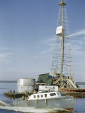 Speedboat Carrying Oil Well Crewmen Passes a Derrick