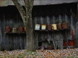 Old Rusted Cans Lined Up on a Shelf on the Side of a Barn