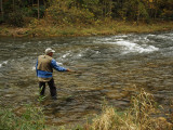 Man Fly-Fishing in a Swift Moving River