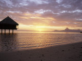 Bungalows over the Water at Sunset at an Exclusive Hotel on Tahiti