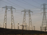 Windmills at a Electricity Producing Wind Farm and High Voltage Lines