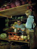 Farmer at His Vegetable Stand Weighs His Produce in Lamplight