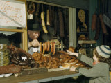 Vendor Holds Up Sausages for Young Girl to Point Out Her Selection
