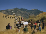 Art Students Draw a Woman Seated Outside an Adobe Home