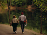 Couple Walking by the Water Along a Park Road
