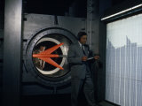 Men Study Readings of Pressure on Wings of Model Plane in Wind Tunnel