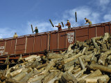 Men Unload Logs from a Railroad Car at a Paper Company